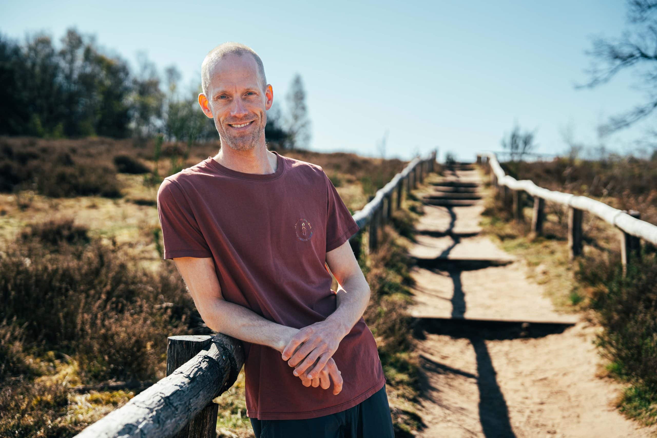 Daan Karsten lacht en leunt op een balustrade – lichaamsgerichte therapie voor mannen